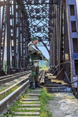 A serviceman guarding the railway tracks with automatic weapons