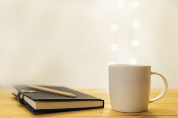 glass with notebook and pencil on the table