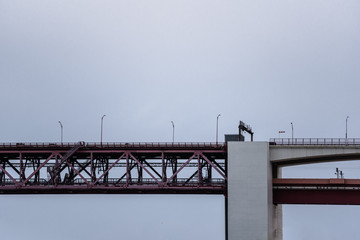 Sideview of red steel beam and concrete pillar bridge
