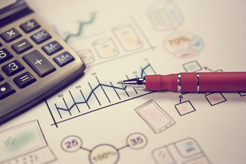 Pen on sketches financial chart and graph, accounting background