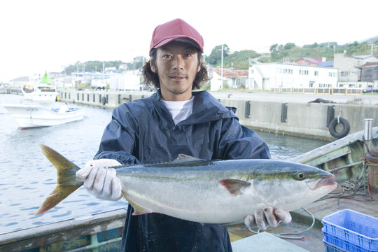 Portrait of fisherman holding fish