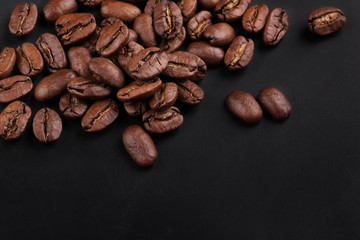 cracked grains of black fried coffee. slate background