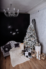The room decorated by Christmas. A big fir-tree with Christmas jewelry and gifts