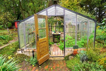 Greenhouse with bricks and tomatoes in a garden