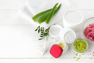 Spa concept with salt, mint, lotion, towel on white background