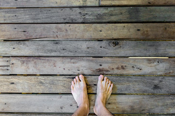 Man's feet stand on old plank wood