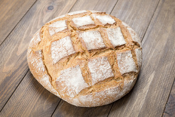 Round bread on wooden table. Food