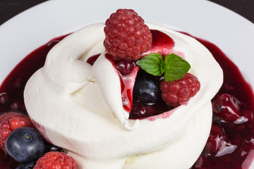 homemade pavlova meringue cake with raspberries and blueberries