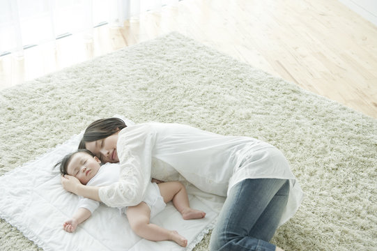 Mother with baby lying on carpet