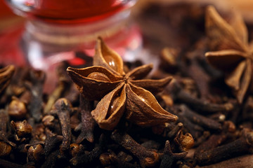 Star anise spice on clove wooden background macro.