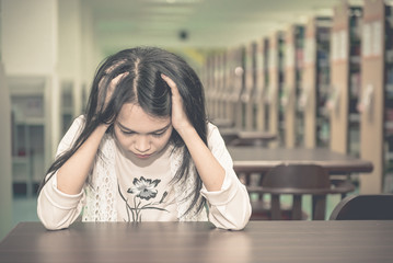 Asian sad girl in the library vintage style,thai woman stress from love,heartbreak concept,dark tone