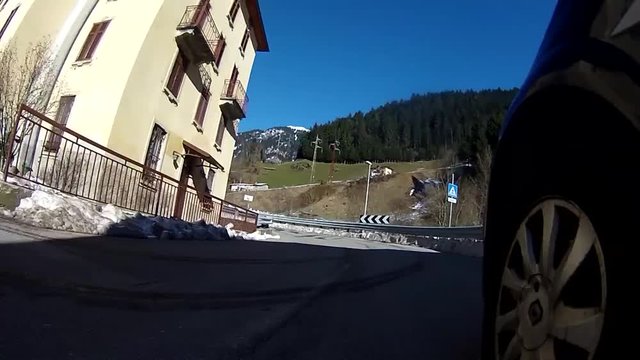 Strada in inverno con la neve sulle Alpi Italiane ripresa dall'automobile