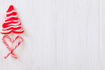 Christmas candy cane lollipop Christmas tree over white wooden textured background