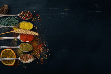 Fototapeta na wymiar Spices and herbs. A large assortment of spices. Indian cuisine. On the wooden table. Top view. Free space for text.