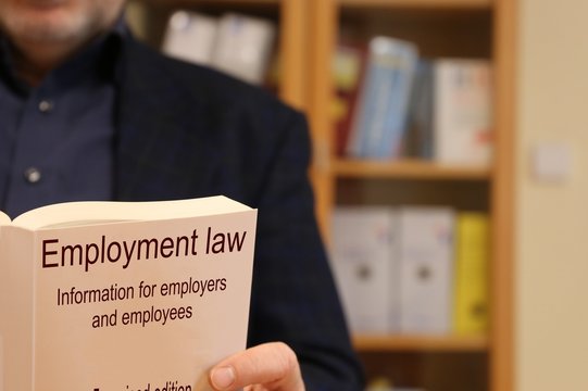 Lawyer for employment law holding a book in his hands