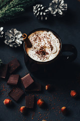 Obraz na płótnie Canvas hot chocolate in a Christmas atmosphere, dark mug with whipped cream