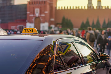 taxi to the center of the city on a busy street with many people and reflected in the glass evening...