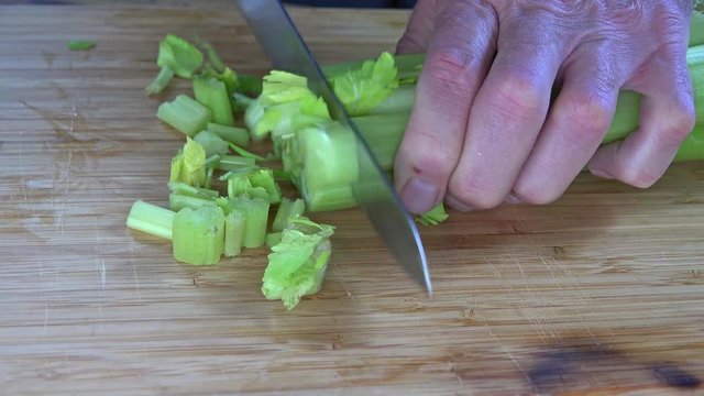 Dicing celery on a cutting board, 4k