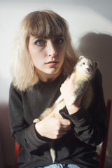 Blond girl holding a pet ferret - obrazy, fototapety, plakaty