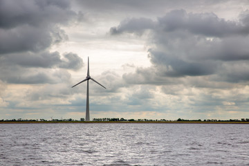 Wind turbine at Dutch coast near Urk with threatening dark sky