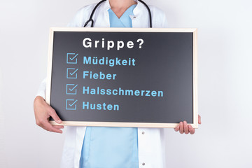 Arzt hält Schild mit Grippe und Symptomen hoch