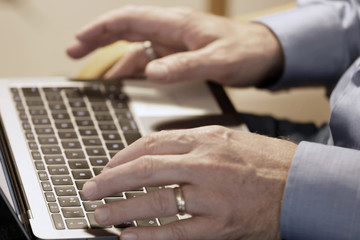 Hands of a businessman typing on a computer keyboard