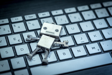Roboter auf Tastatur, Methapher für Chatbot / Socialbot, Algorithmen und künstliche Intelligenz 