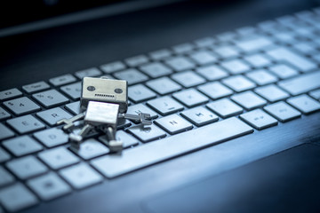 Roboter auf Tastatur, Methapher für Chatbot / Socialbot, Algorithmen und künstliche Intelligenz 