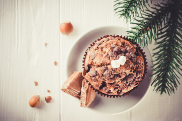 Chocolate muffin on white wooden background.
