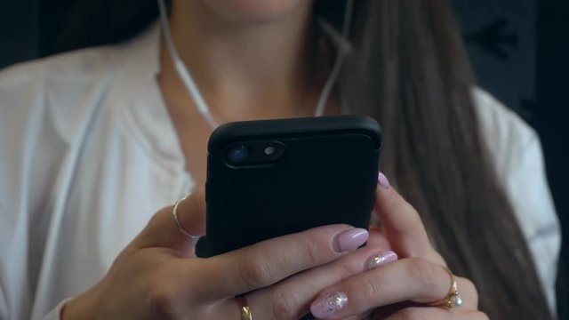 A young lady's hands using a smartphone in the train. Soft focus. Close-up shot
