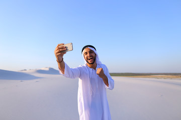 Portrait of Arabian sheikh man with gadget that communicates in 