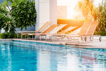 wooden bench on wooden deck nearby swimming pool