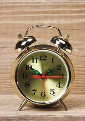 golden alarm clock  on  wooden table