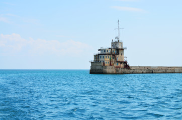 In the sea stands a lighthouse.