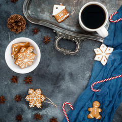 Christmas composition. Gingerbread, candy cane and coffee cup on dark background. New year concept