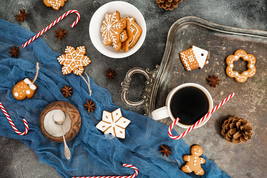 Gingerbread, candy cane and coffee cup on dark table. Christmas composition. © artifirsov