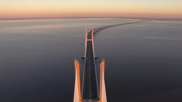 Vasco da Gama bridge over the Tagus river at sunset in Lisbon, Portugal, aerial view.
