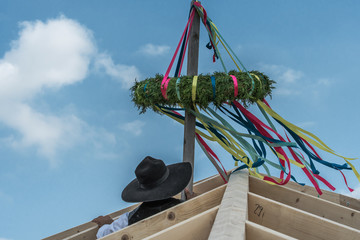 Traditional ceremony with a wreath on the roof construction is a crowning event