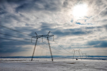 High voltage poles in a snow field in the winter