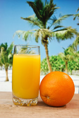 Glass of orange juice on a beach