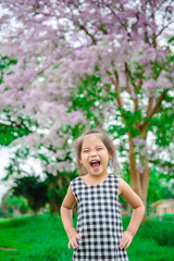 Portrait of cute little girl on beautiful flowers on tree background,colorful tone