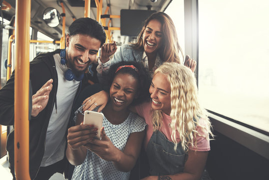 Diverse Group Of Friends Using A Cellphone On The Bus