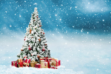 Fototapeta na wymiar verschneiter und geschmückter Weihnachtsbaum im Schneetreiben mit vielen Geschenkpäckchen