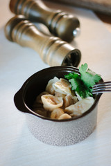 Russian meat dumplings called pelmeni at ceramic bowl.