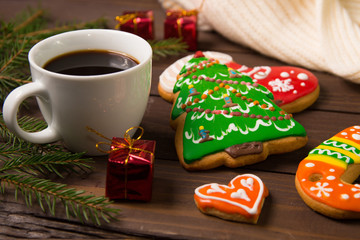Cup of coffee in Christmas , gingerbread  and christmas decorations on the wooden background .
