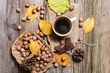 cup of black coffee with chocolated and nuts standing on wooden table