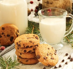 Chocolate chip cookies and glass of milk on festive Xmas background, selective focus