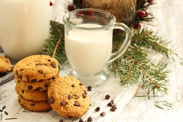 Chocolate chip cookies and glass of milk on festive Xmas background, selective focus