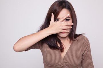 Fototapeta premium Beautiful young Asian woman peeking through fingers.