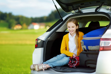 Adorable little girl ready to go on vacations with her parents. Child relaxing in a car before a road trip.